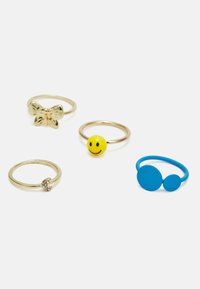 Quatro anéis: um design de arco em ouro, uma banda de ouro com um rosto sorridente amarelo, um anel de ouro com uma pequena pedra de diamante e uma banda azul com dois círculos.