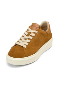 Sneaker in suede marrone con suola in gomma crema, punta rotonda, lacci crema e accentuazione in pelle beige sul tallone. Design minimalista, tomaia texturizzata.