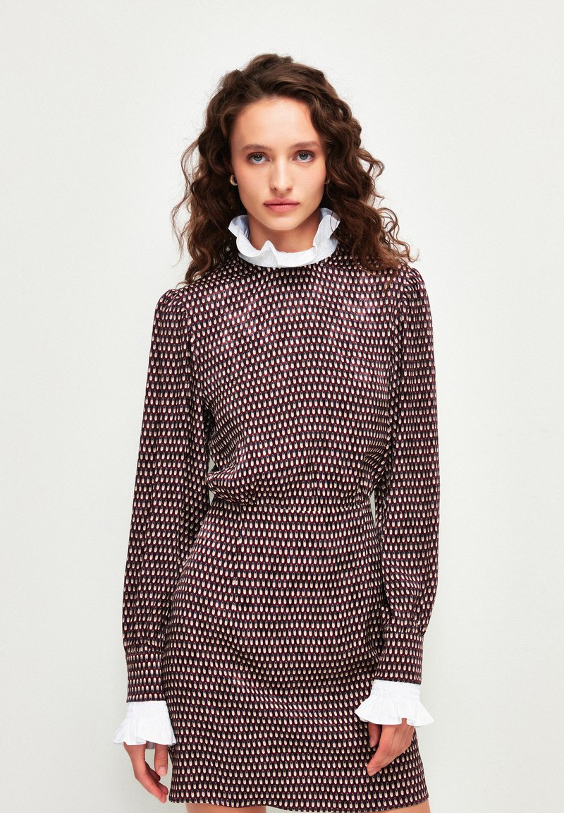 Robe marron à motifs avec des manches longues, encolure blanche froncée, taille cintrée et texture lisse. Motif géométrique multicolore sur l'ensemble.