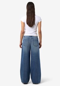 Δαχτυλίδια τζιν με φαρδιά καμπάνα, σε ανοιχτό μπλε χρώμα, με ψηλή μέση, δύο πίσω τσέπες και τυπικό σχέδιο πέντε τσεπών.