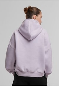 Svijetloplavi oversized hoodie s kapuljačom na vezanje, rebrastim manžetama i porubom, te mekom teksturom, prikazan s leđa bez vidljivih logotipa.