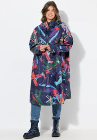 Cappotto impermeabile lungo e colorato con cappuccio, caratterizzato da un design astratto in rosso, verde, blu e viola su uno sfondo scuro.