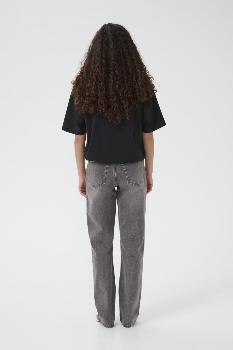 Haut noir à manches courtes et jean gris à taille haute avec une légère texture, coutures visibles et poches arrière, vus de dos.