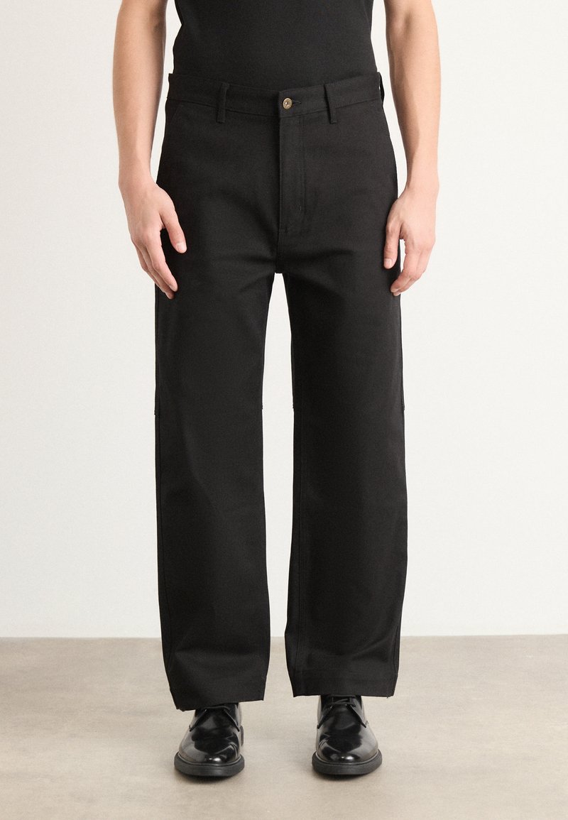 Black wide-leg trousers made of sturdy fabric, featuring a front button closure, side pockets, and a smooth, flat waistband.