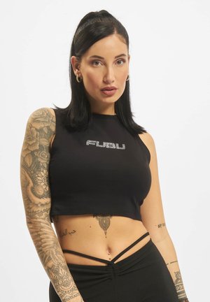 Černý cropped top s kamínkovým nápisem; hladký materiál; má vysoký výstřih a detailní ramínka, spojené s kalhotami s vysokým pasem.