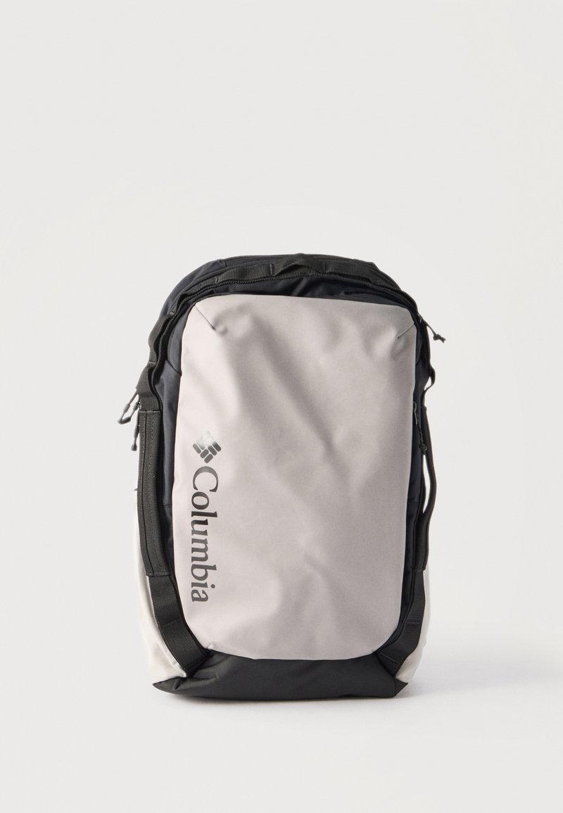 Svetlosivý a čierny batoh Columbia s vertikálnym logom na prednom vrecku, nosným úchytom na vrchu a zipsovým zatváraním.