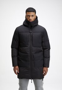 Giacca imbottita nera con colletto alto, trapuntatura orizzontale, chiusura frontale con zip e due ampie tasche. Presenta un materiale testurizzato e cappuccio regolabile.