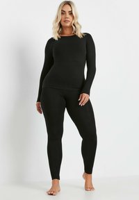 Zwart set met lange mouwen en legging in een fitted ontwerp. Gladde, rekbare stof met een ronde halslijn, zonder versieringen of patronen.