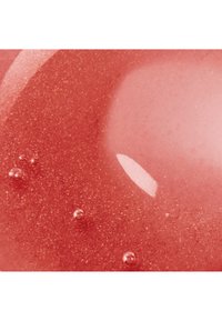Surface liquide rouge glossy avec de petites bulles et une tache lumineuse réfléchissante créant texture et profondeur.