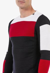 Strickpullover mit horizontalen Streifen in Rot, Weiß und Schwarz; strukturierte Rippung an den Ärmeln; Rundhalsausschnitt, taillierte Passform.