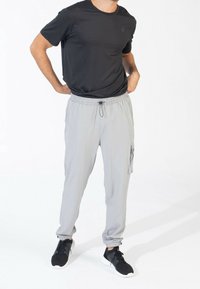 Gray lightweight jogger pants with elastic cuffs and side pockets, paired with a black short-sleeve t-shirt, suitable for casual wear.