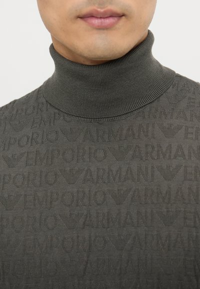 Maglione a collo alto grigio scuro con un design testurizzato caratterizzato da modelli ripetuti del logo "Emporio Armani" in sfumature leggermente diverse.