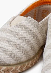 Espadrile v svetlo sivi in smetanasti črtasti tkanini z narejenim jute podplatom, zaobljenim nosom in kontrastnim oranžnim notranjim podlogom.