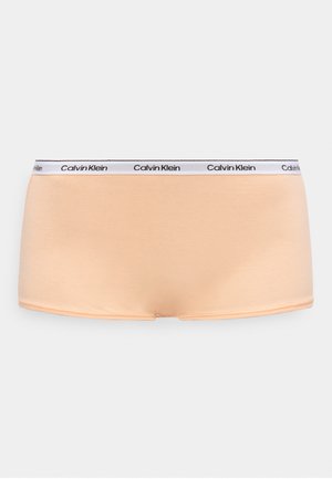 Peach-colored women’s boyshort underwear with white elastic waistband featuring repeated Calvin Klein logo in black.