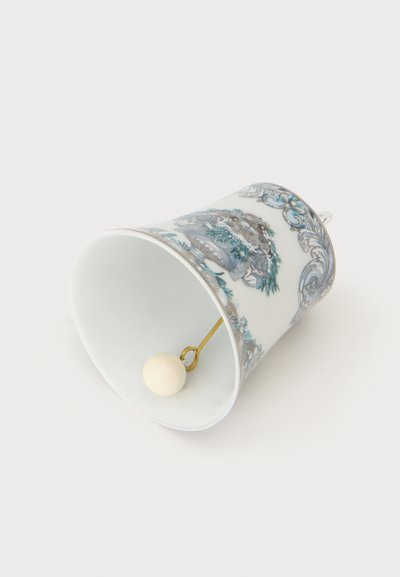 Cloche en porcelaine avec des motifs décoratifs bleus et argentés et un battant rond blanc à l'intérieur, présentée couchée sur le côté.