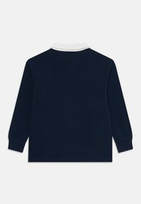 Marinblå långärmad polo med vit krage. 100% bomull, avslappnad passform, utan mönster eller grafik, enfärgad baksida.