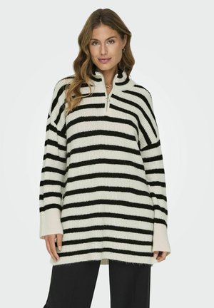 Pull en tricot à rayures noir et blanc avec col zippé à mi-hauteur, manches longues, coupe légèrement oversize et finition douce et texturée.