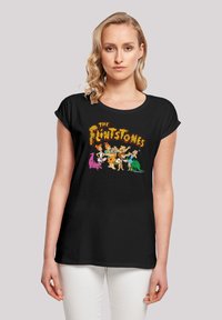 Svart T-skjorte med grafikk av "The Flintstones" og fargerike tegneseriefigurer. Mykt stoff, avslappet passform, korte ermer.