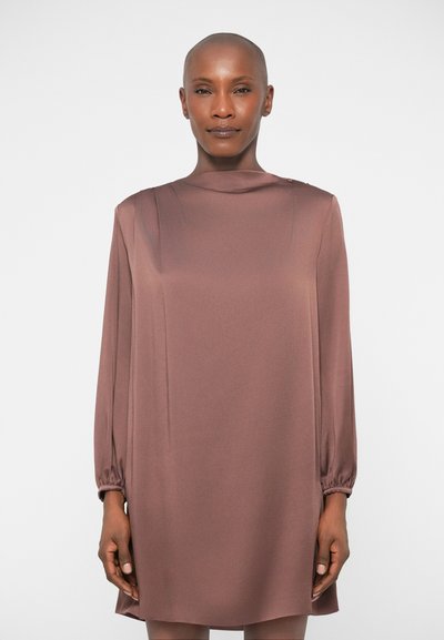 Robe en satin marron avec de longues manches volumineuses et un col haut. Présente de petits boutons aux épaules et une coupe décontractée.
