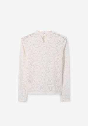 Haut à manches longues en dentelle de couleur blanc cassé avec un motif floral, fermeture à l'arrière en forme de clé, et finition douce et texturée, avec un col rond.