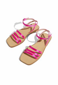 Rosa Satin-Sandalen mit drei breiten Riemen, quadratischer Zehenpartie und Knöchelriemen mit einer silbernen Schnalle. Die beigefarbene Sohle sorgt für einen Kontrast.
