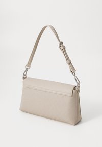 Sac à main synthétique beige avec une forme structurée, bandoulière réglable et ferrures en ton argent ; présente un motif texturé subtil.