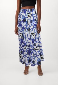 Gonna maxi floreale in tessuto leggero, con un motivo astratto blu e bianco con accenti neri, bottoni frontali e un design fluido.