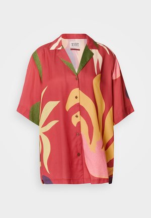 Camisa de manga corta con botones en color óxido con grandes patrones florales abstractos en amarillo, verde y rosa. Textura de tela suave.