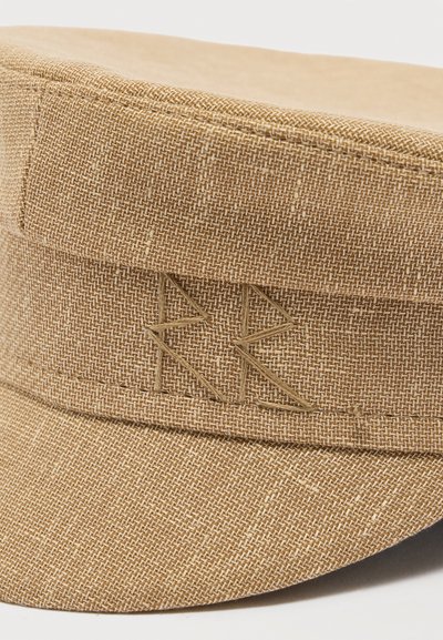 Καπέλο από υφασμάτινο ύφασμα σε ανοιχτό καφέ χρώμα με ραμμένο γεωμετρικό σχέδιο στο μπροστινό μέρος, που δείχνει λεπτομερή ύφανση και ενισχυμένες ραφές.