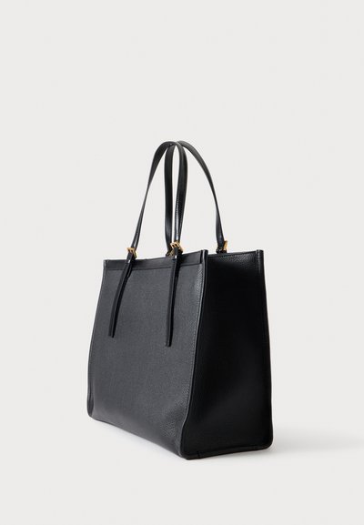 Sac cabas en cuir noir texturé avec deux longues anses et des ferrures dorées sur un fond clair uni.