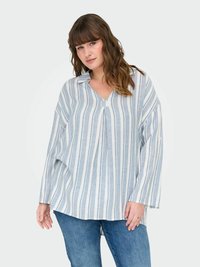 Chemise à rayures bleues et blanches, ample, avec un col en V et des manches longues, fabriquée dans un tissu léger. Associée à un jean en denim.