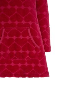 Punainen fleece-mekko, jossa on sydänkuvioinen pinta, kaksi etutaskua ja pitkät hihat. Pehmeä materiaali, joka on rentoa malliltaan.