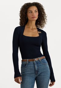 Navy ribbed long-sleeve top featuring a square neckline and a gold buckle accent. Paired with light blue jeans and a brown belt.
