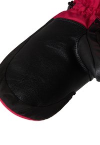 Črna usnjena rokavica z rdečim najlonskim vrhom. Ima teksturirano dlan in elastičen zapestni del za tesno prileganje. Ojačani šivi so vidni.