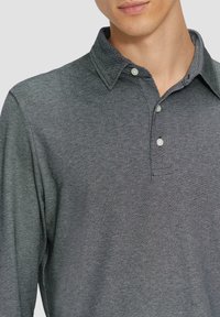 Dunkelgraues Langarm-Poloshirt aus strukturiertem Stoff, mit klassischem Kragen und zwei Knöpfen vorne.