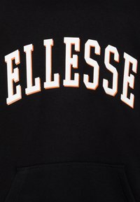 Tessuto nero con testo "ELLESSE" in grassetto e font arcuato, bordato di bianco e arancione, sopra una tasca cucita.