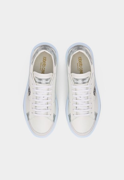 Ζευγάρι λευκά χαμηλά αθλητικά παπούτσια με ασημί λεπτομέρειες, κορδόνια και τη σήμανση «Roberto Cavalli» στο εσωτερικό και στη γλώσσα, σε θέαση από πάνω.