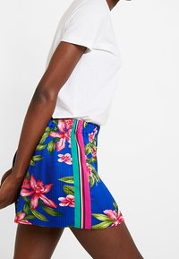 Bloemige geplooide mini-jurk in levendig blauw, met roze en groene gestreepte accenten en een tailleband voor een verstelbare pasvorm.