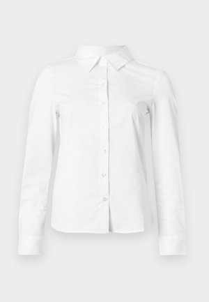 Fehér, hosszú ujjú ing, gombos, hegyes gallérral, egyenes szegéllyel és testhez simuló szabással, egyszerű világos háttéren bemutatva.