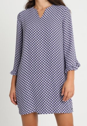 Een jurk met een patroon van paarse en witte diamanten, met lange mouwen en een V-hals, gemaakt van lichte stof.