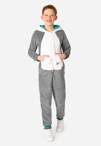 Sivý a biely flísový overal s dlhými rukávmi, kapucňou a prednými vreckami. Má kapucňu s tyrkysovým lemovaním a malý detail banánu.