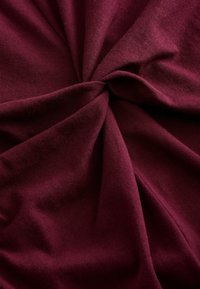 Burgundy-kangas kierretty tekstuurin luomiseksi, pehmeästä puuvillasekoitteesta valmistettu; sileä pinta, jossa on hieman venyvyyttä ja matta viimeistely.