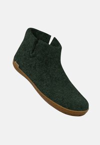 Stivaletti alla caviglia in feltro verde con un design minimalista, caratterizzati da un dettaglio a taglio e una suola in gomma marrone per trazione e durata.