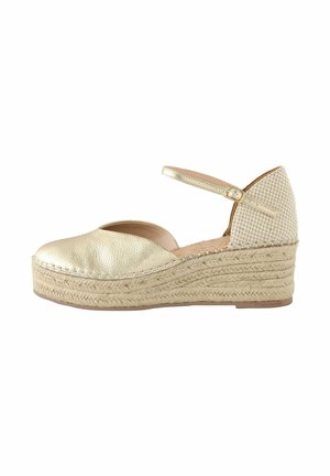 Gold leather espadrille wedge with a textured upper and a woven jute platform. Features a strap with a buckle at the ankle.
