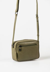 Borsa a tracolla in pelle verde oliva con forma rettangolare, tasca frontale con zip e tracolla regolabile. Texture liscia, design minimalista.