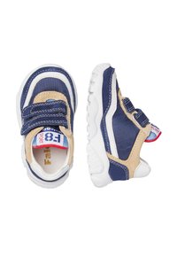 Dětské sportovní boty v námořnické modré, béžové a bílé barvě, s dvojitým suchým zipem a bílou gumovou podrážkou, zobrazené z horního a bočního pohledu.