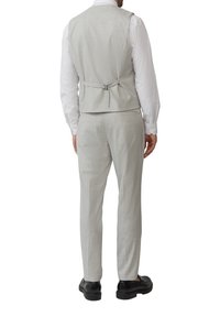 Costume trois pièces gris clair avec un motif à carreaux, comprenant un gilet sans manches avec une ceinture dans le dos, coupe ajustée et pantalon assorti.