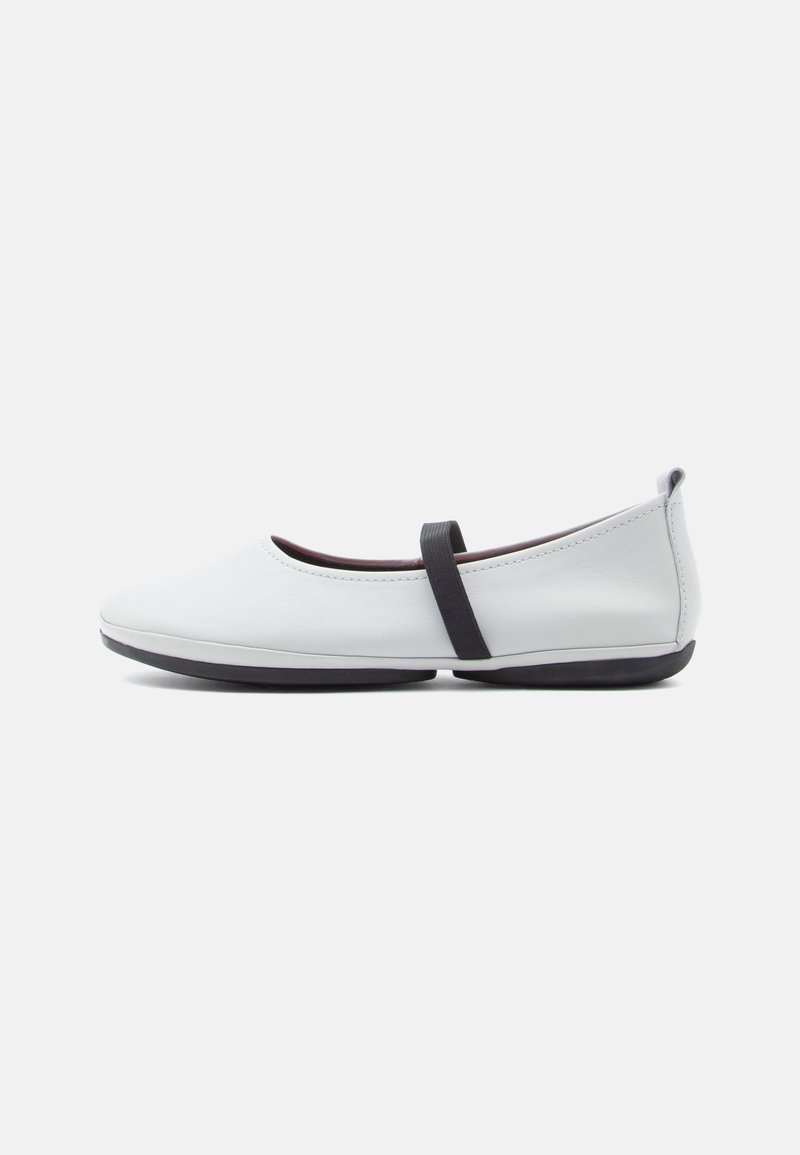 Λευκές μπαλαρίνες από λείο δέρμα, με χαμηλό προφίλ, στρογγυλεμένη μύτη και μαύρο ελαστικό λουράκι στο κουντεπιέ.