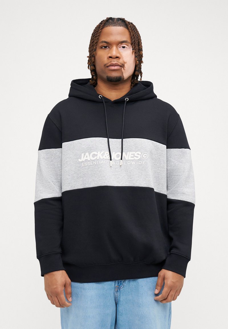 Zwarte en grijze hoodie met een voorke pocket, trekkoorden en een logo-opdruk. Heeft een kleurblokontwerp met een zachte textuur.