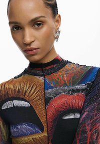 Pikad varrukad, kehale hästi sobiv ülaosa, millel on erksad huulte ja silmade graafilised trükised, valmistatud venivast kangast musta, punase ja sinise toonides.